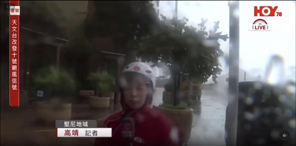 高靖在報道新聞期間見她站在岸邊十米外位置,鏡頭幾乎已被雨水遮蔽。