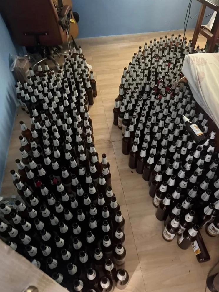 死者房間內超過100個啤酒樽整齊地排列在地上,只留下一條小路進出。(互聯網)