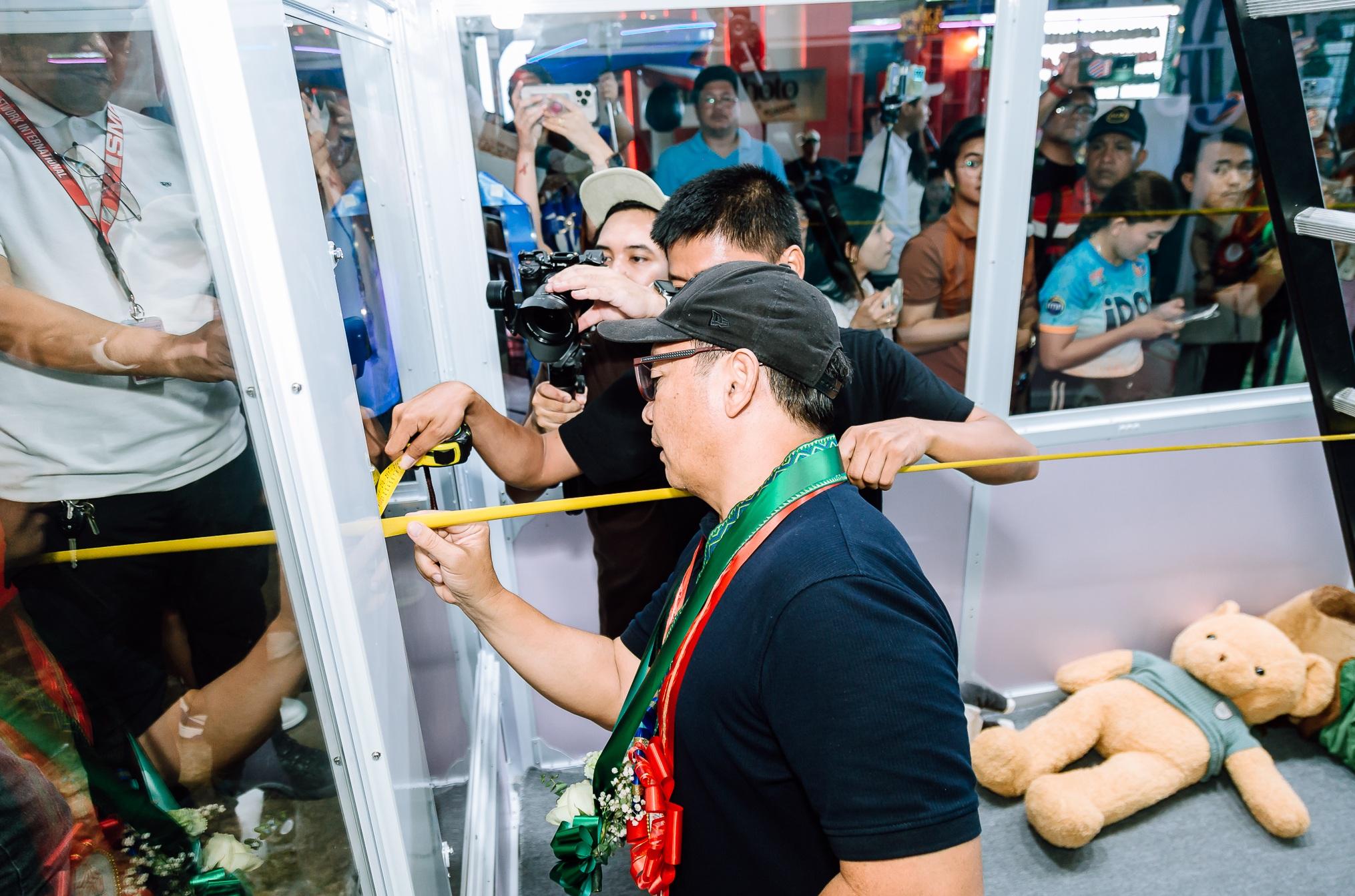 菲律賓宿霧的「爪王」(Claw King)夾公仔機,將挑戰健力士世界紀錄,工作人員量度其尺寸。(互聯網)