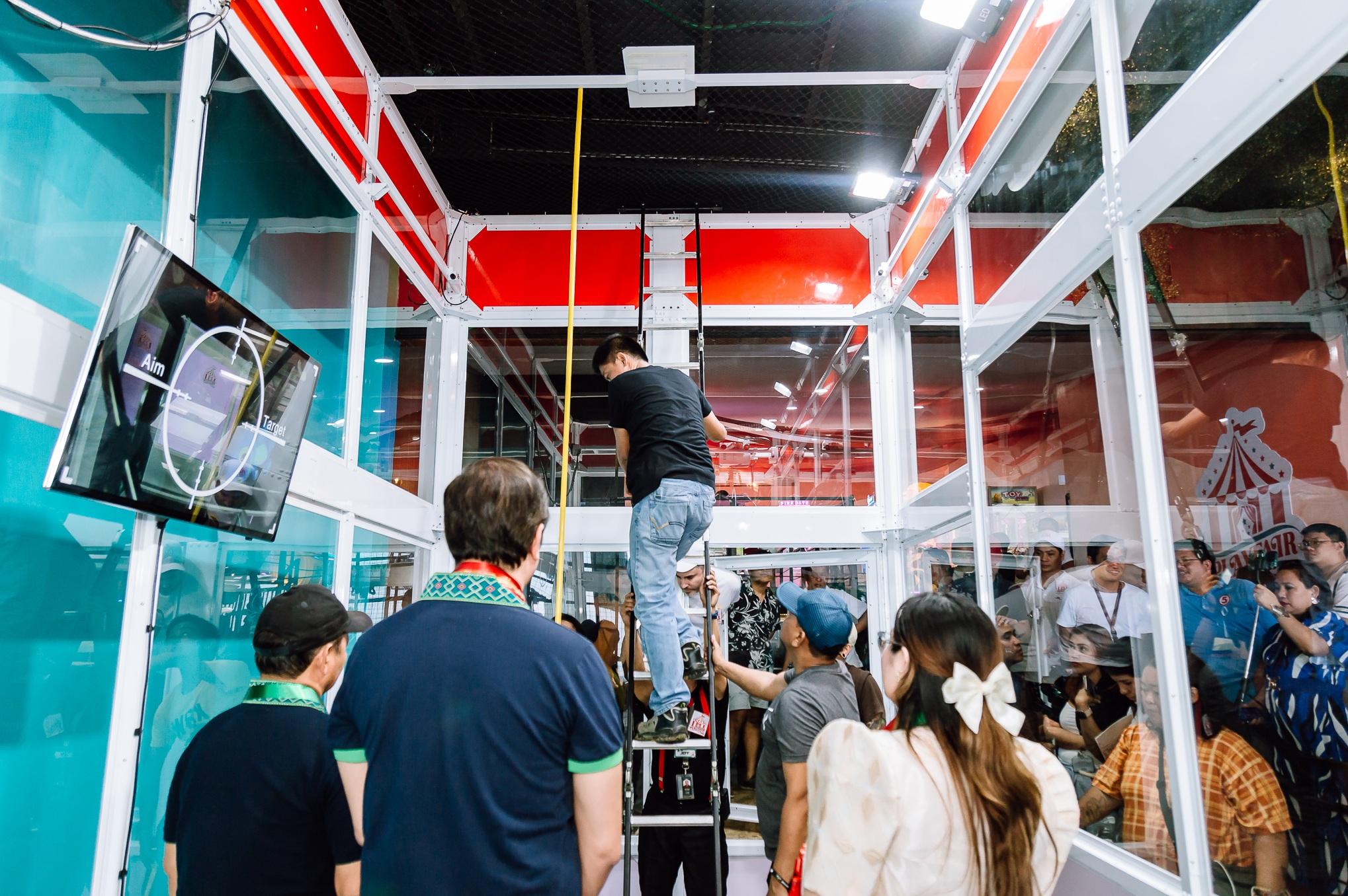 菲律賓宿霧的「爪王」(Claw King)夾公仔機,將挑戰健力士世界紀錄,工作人員量度其尺寸。(互聯網)