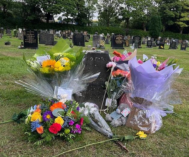 親友在十字架崩塌的墳墓前獻上鮮花和泰迪熊悼念男童。(互聯網)