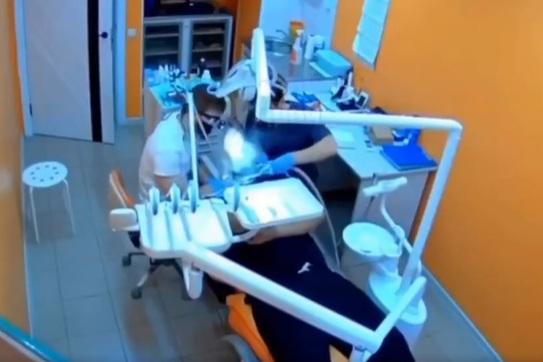 牙醫專注洗牙時,工具突然在病人口裡爆炸,閃出火光。(互聯網)