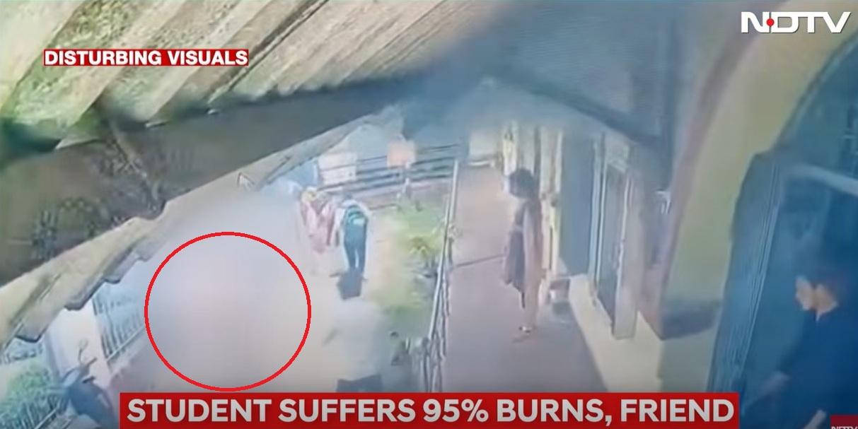 女學生再跑回畫面左邊,旁邊一名男子試圖用手拍熄火勢。(互聯網)