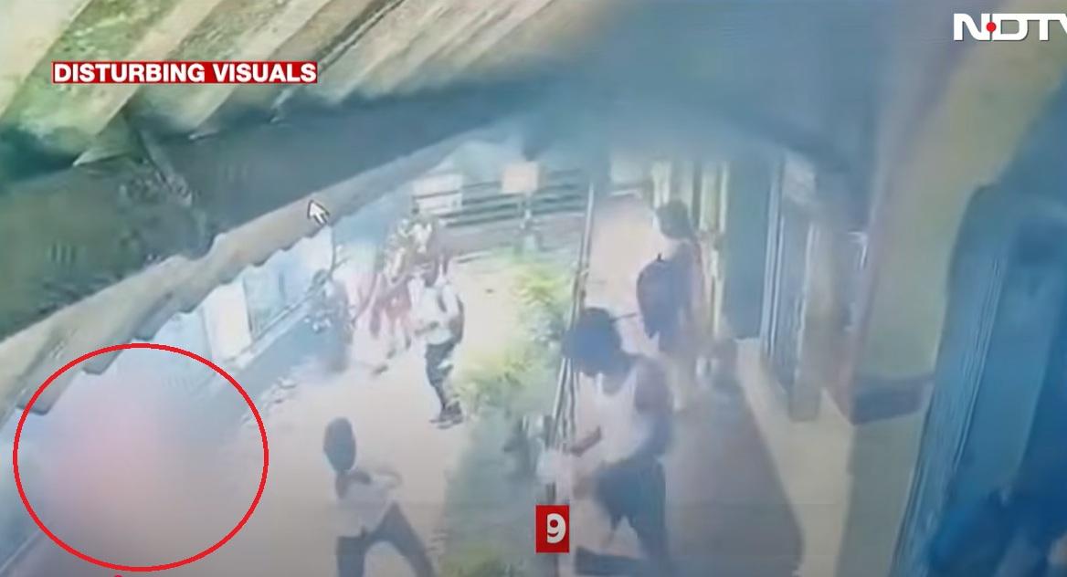 女學生再跑回畫面左邊,旁邊一名男子試圖用手拍熄火勢。(互聯網)