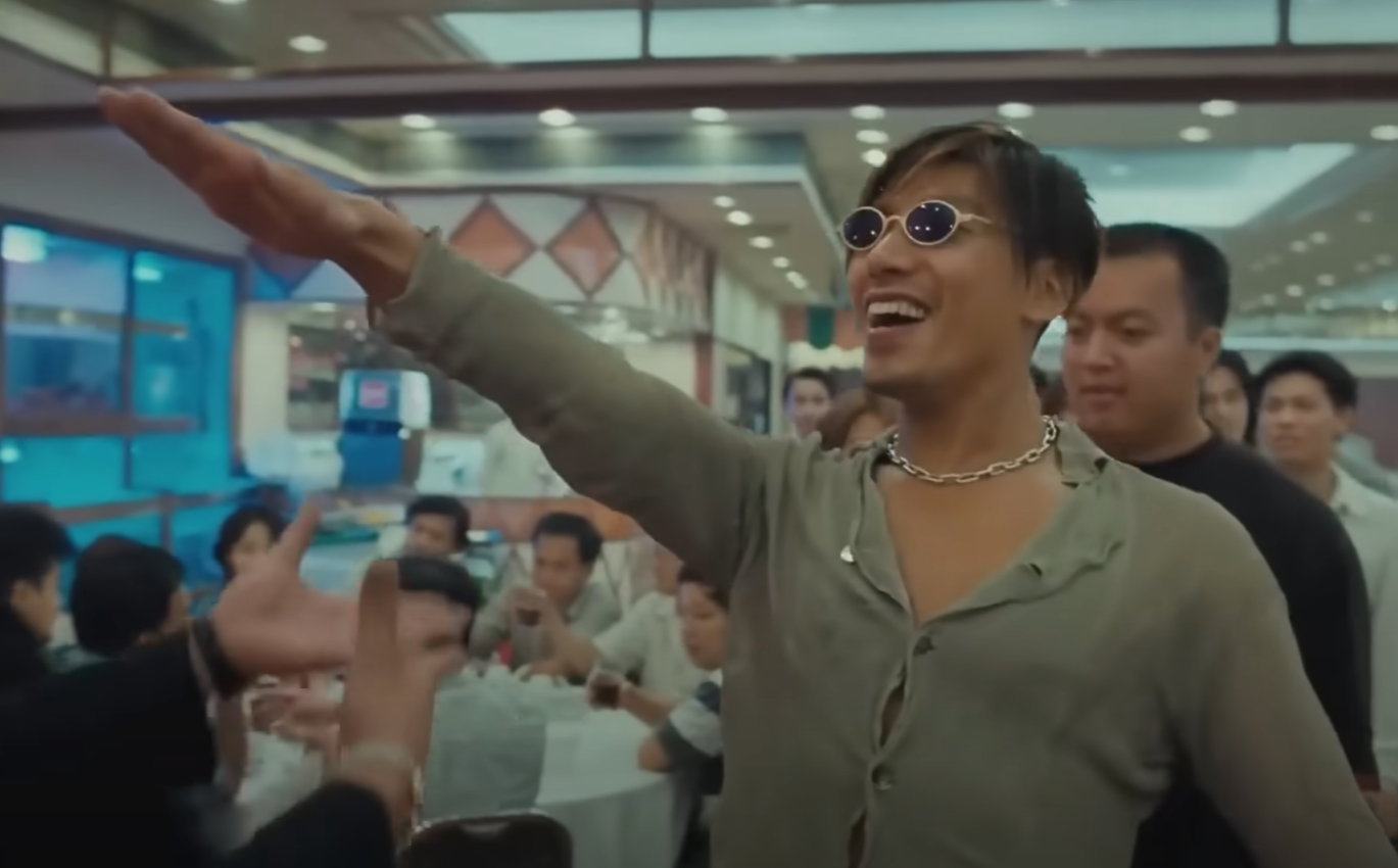 1996年港產電影《古惑仔3之隻手遮天》電影、由張耀揚演出的反派角色「烏鴉」於進入酒樓出席關帝君誕辰宴會的經典打招呼手勢(影片截圖)