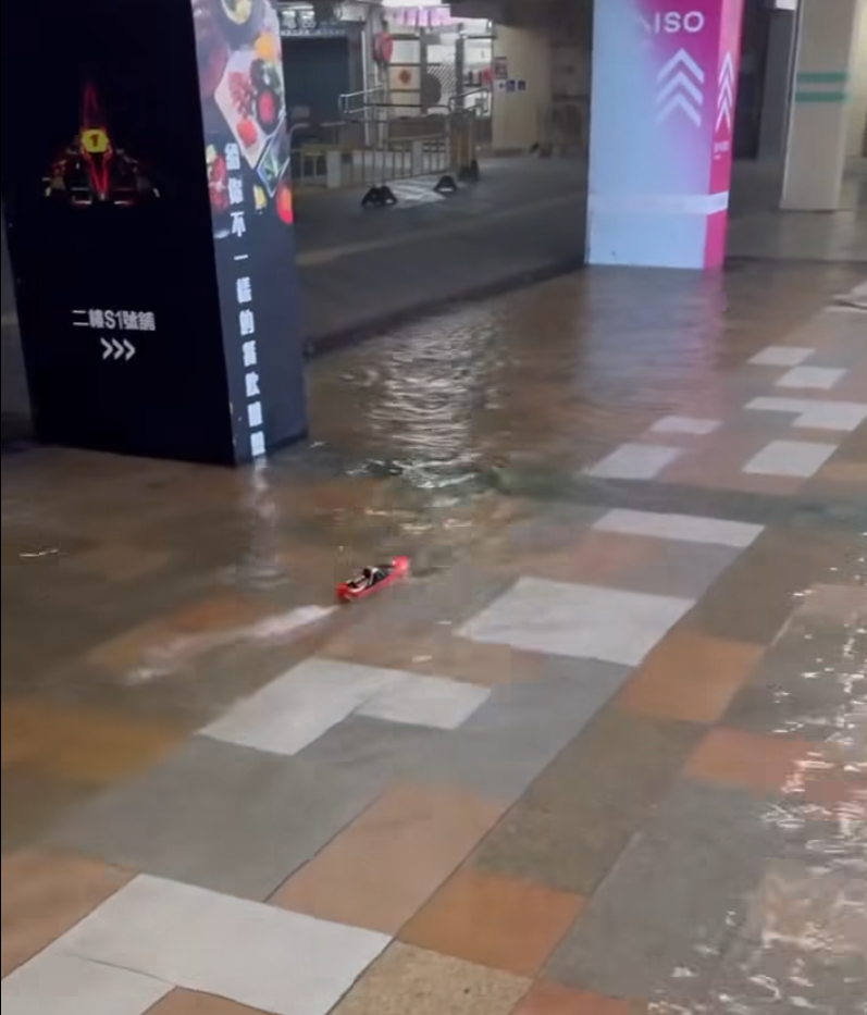 何文田愛民邨商場愛民廣場有人「雨中作樂」,在水浸的商場內放遙控船。(影片截圖)