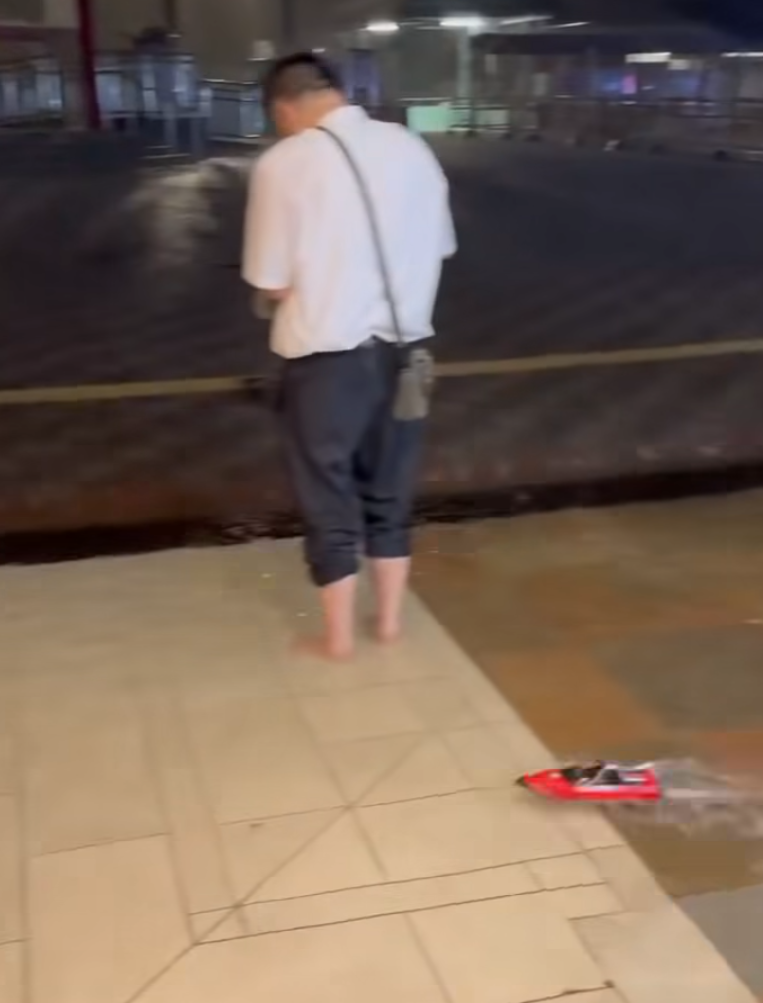 何文田愛民邨商場愛民廣場有人「雨中作樂」,在水浸的商場內放遙控船。(影片截圖)