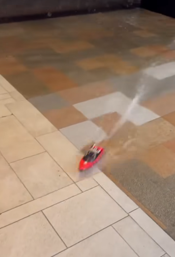 何文田愛民邨商場愛民廣場有人「雨中作樂」,在水浸的商場內放遙控船。(影片截圖)