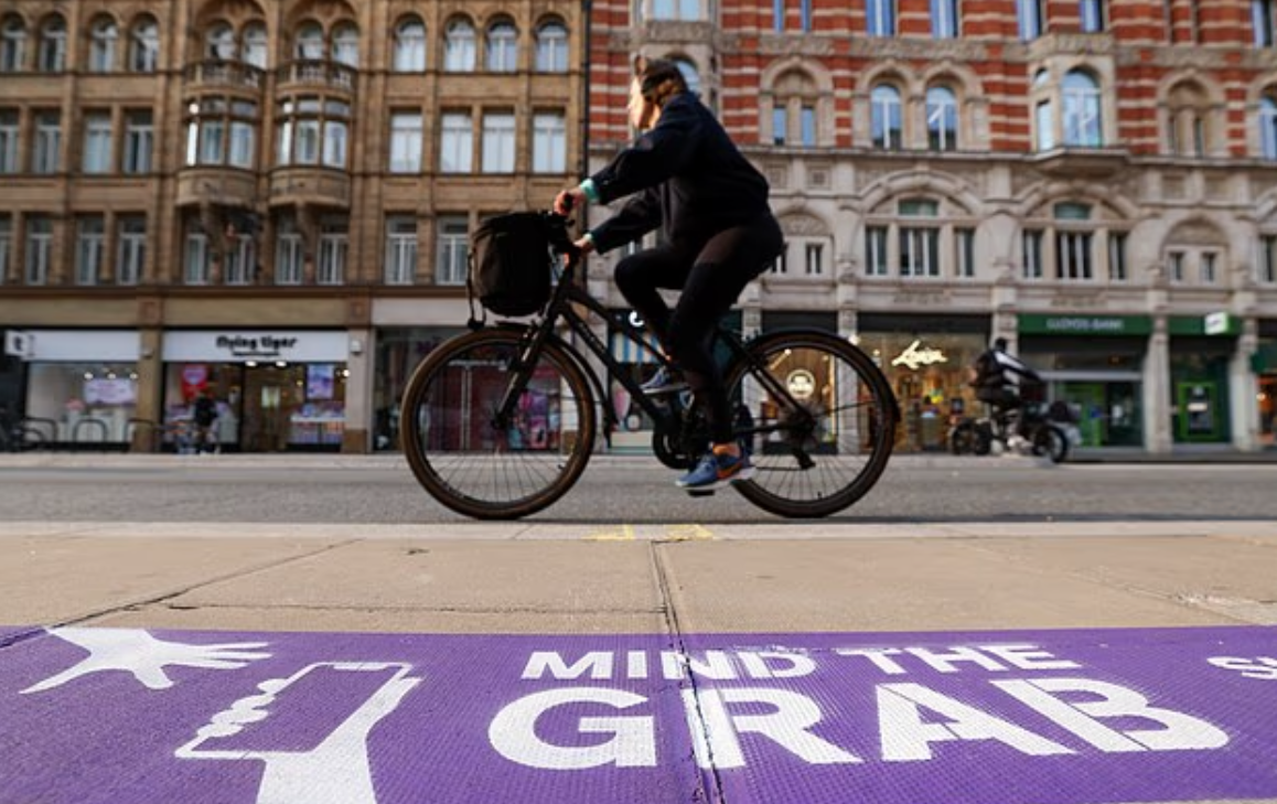 當地警方在牛津街某個搶手機熱點的行人路上,加上寫有食字「Mind the Grab」的紫色線,提醒民眾小心手機被搶。(互聯網)