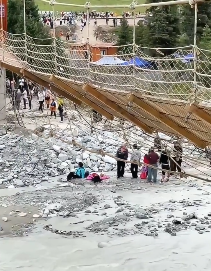 新疆伊犁哈薩克自治州一個景區有一座「網紅吊橋」橋索斷裂致橋面傾斜,多人從橋上墮下湍急河流,造成5人死亡,另有24人受傷。(影片截圖)