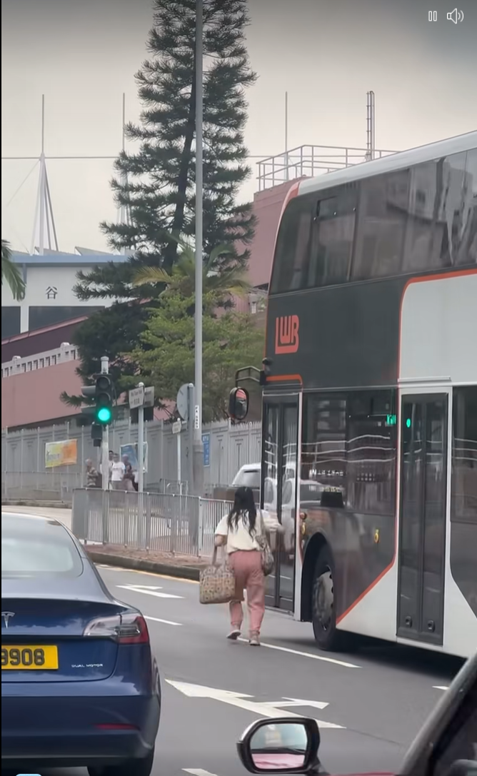 女子跑出馬路拍打巴士車門。(網上影片截圖)