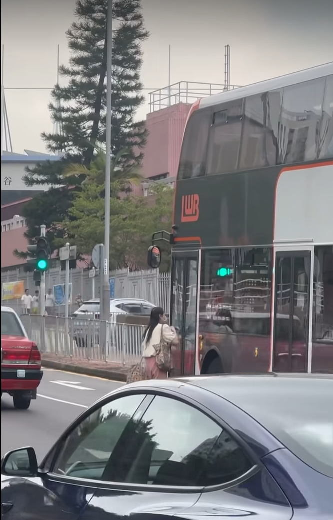 女子跑出馬路拍打巴士車門。(網上影片截圖)