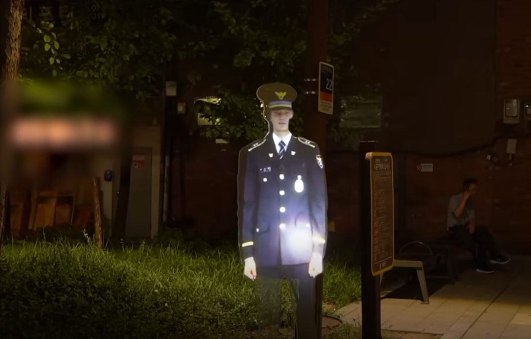 南韓首爾警方為減低犯罪率,在一個治安黑點公園設置投影警察「站崗」,警方表示設置裝置後,公園周邊犯罪率較同年下降22%(影片截圖)
