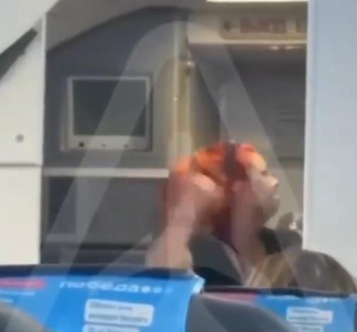 女子連續揮拳,引發周圍乘客驚慌。(X)