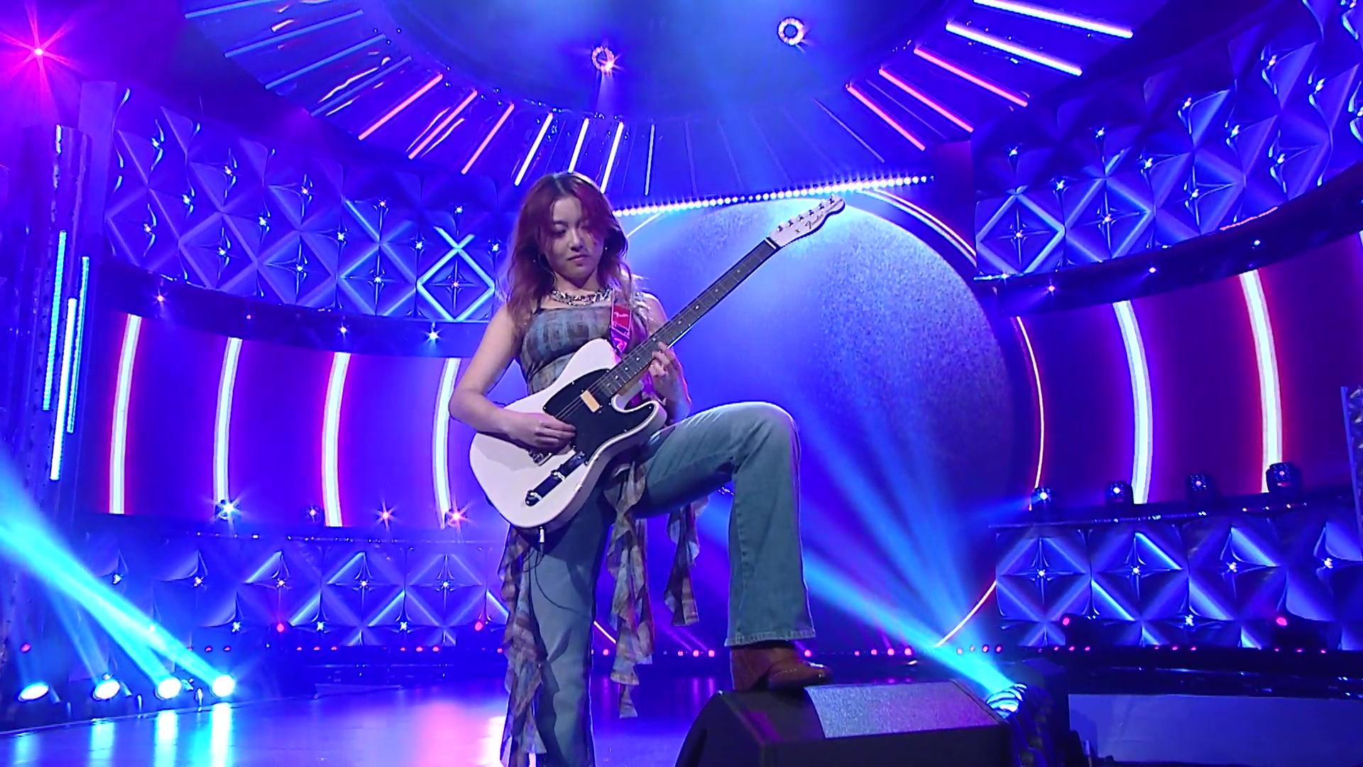 Emily一邊彈電結他一邊踩住台上喇叭。