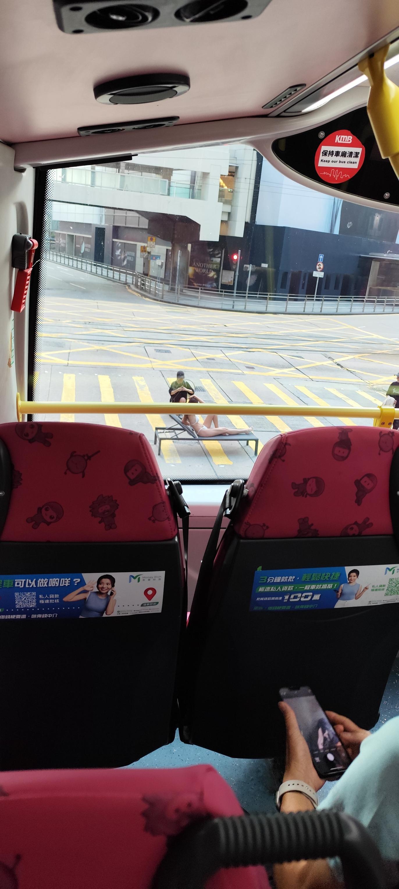 有網民拍得照片,可見位於中環畢打街連接德輔道中的繁忙馬路班馬線上,一名身穿白色三點式泳衣的長髮女子在坐沙灘椅「曬太陽」,引起車上乘客側目拍下「奇景」。(Threads)