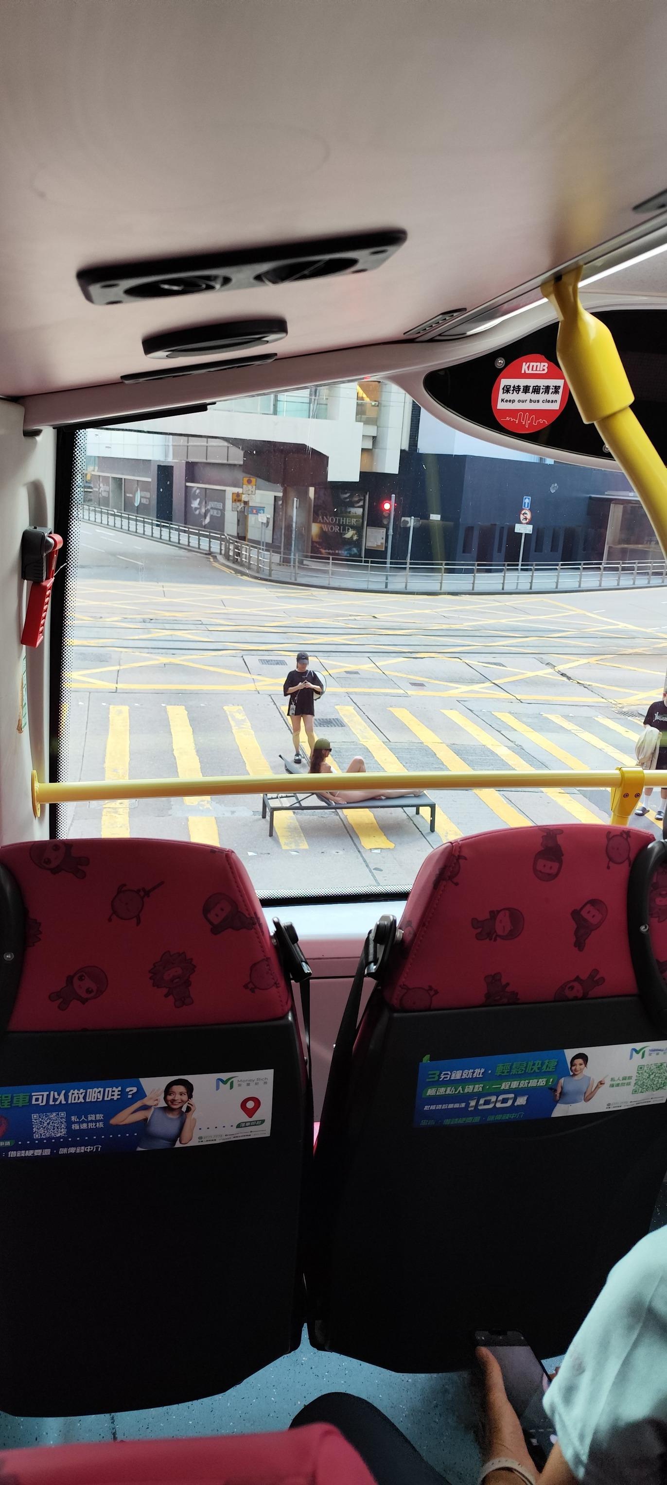 有網民拍得照片,可見位於中環畢打街連接德輔道中的繁忙馬路班馬線上,一名身穿白色三點式泳衣的長髮女子在坐沙灘椅「曬太陽」,引起車上乘客側目拍下「奇景」。(Threads)