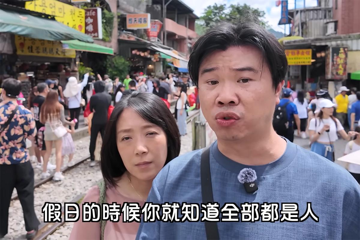 在「菜苔苔與菜生生」拍攝期間,背後仍有很多人橫越或站在路軌上放天燈和拍照。(YouTube影片截圖)