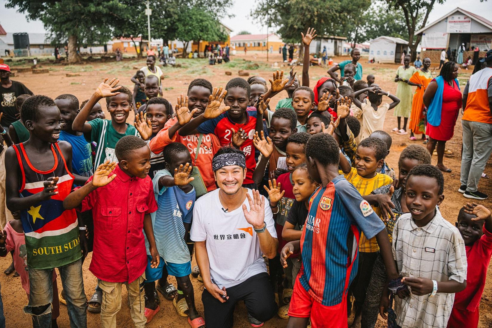 抵達難民收容中心後,好奇的孩子蜂擁圍著吳浩康。