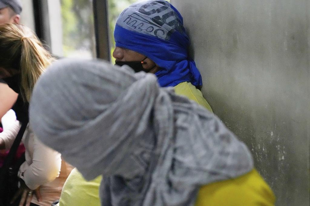 馬尼拉市長周二公布調查進展,兩名被捕疑犯蒙面,被帶到記者會。(美聯社)