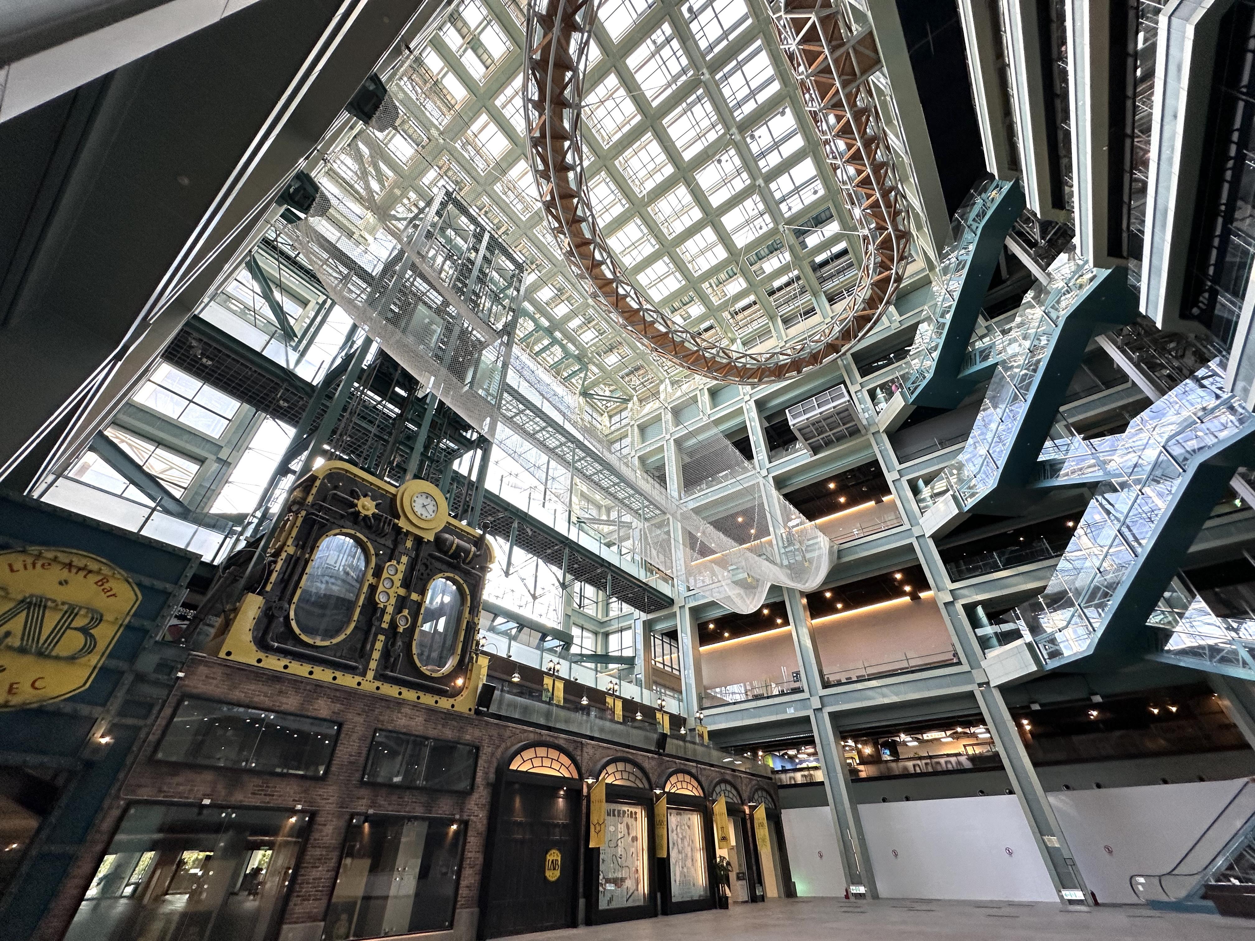 挑高10層樓的大廳,玻璃天窗與帷幕引入自然光。