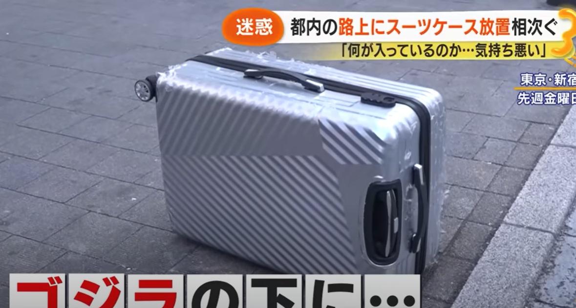 日本媒體報道,有人在東京新宿鬧市丟棄毀爛的舊行李箱。(互聯網)