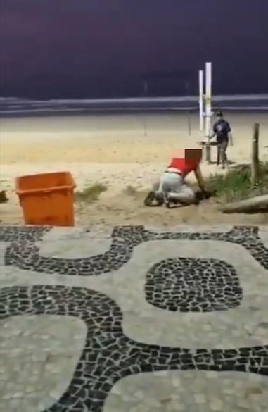 英國遊客在沙灘上「腳步浮浮」,跌倒後站起來。(互聯網)