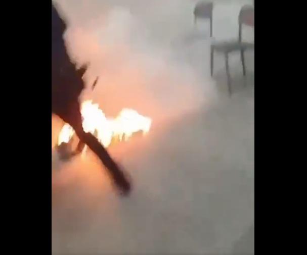 男子倒在地上,保安等人向他噴化學滅火劑。(互聯網)