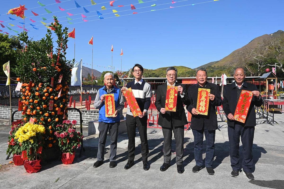 郭永昌(右二)年初曾陪同商務及經濟發展局局長丘應樺(中),到八鄉家訪及派發福袋。(商經局FB)