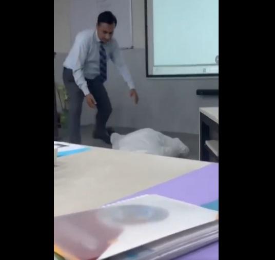 男教師倒下,旁邊的人上前協助。(互聯網)