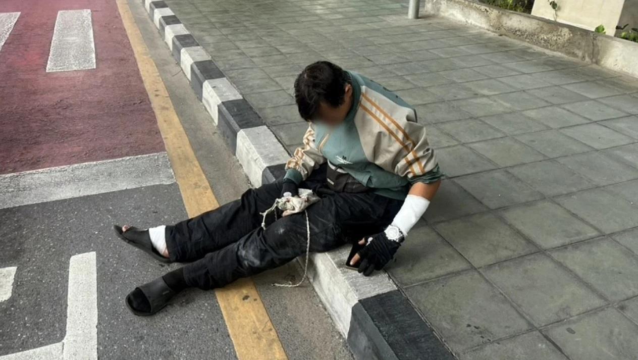 電單車司機受輕傷,救護員替他包紮後坐在路邊。(互聯網)