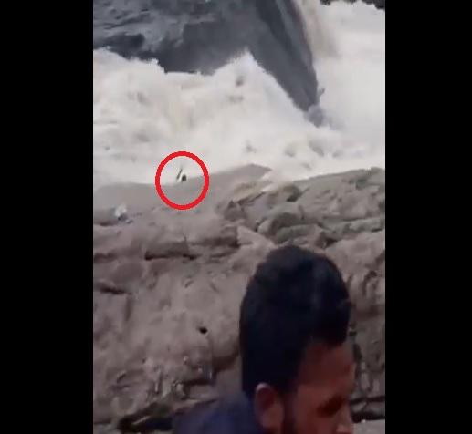 圖杜被山洪沖走,舉手呼救,旁人十分無助。(互聯網)