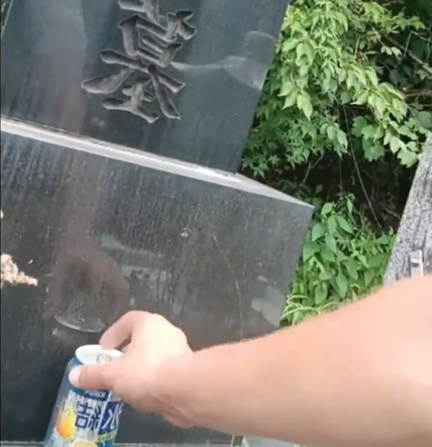男子取走了墓前的啤酒飲用。(影片截圖)