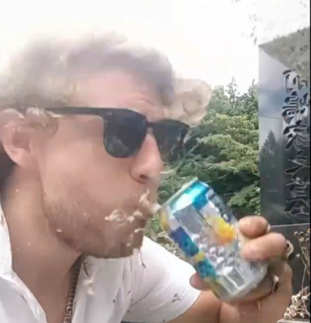 男子取走了墓前的啤酒飲用。(影片截圖)