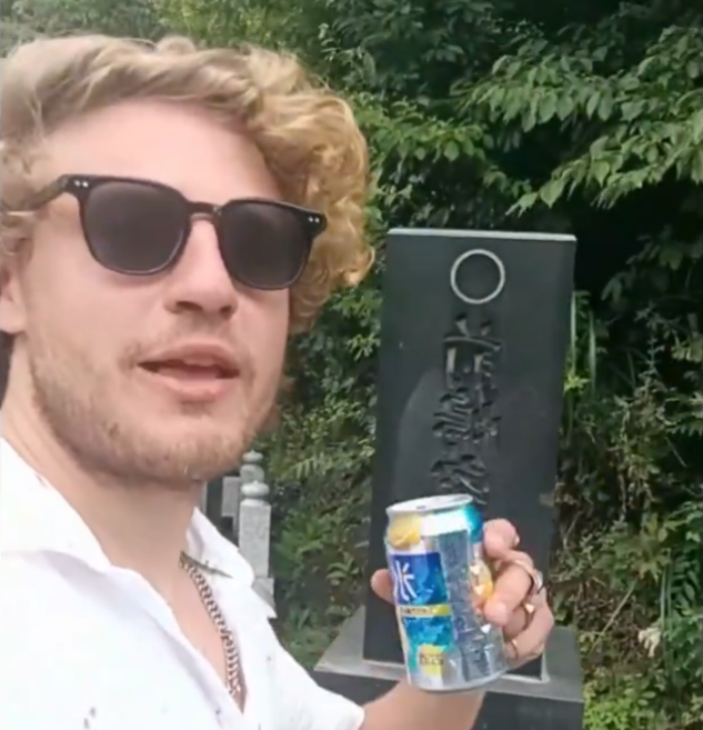 男子取走了墓前的啤酒飲用。(影片截圖)