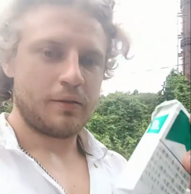 男子在墓前放下香煙。(影片截圖)