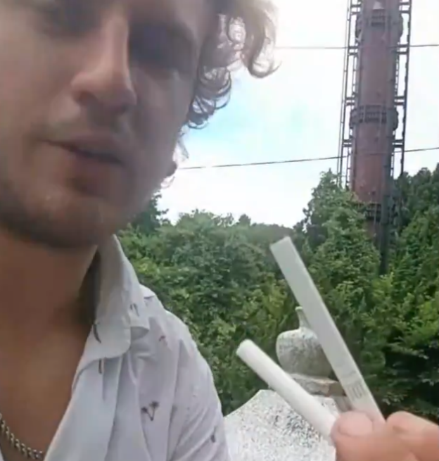 男子在墓前放下香煙。(影片截圖)