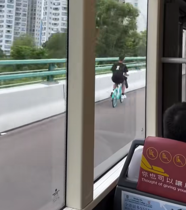 一名男子在屯門公路上沿着路肩踩共享單車。(影片截圖)