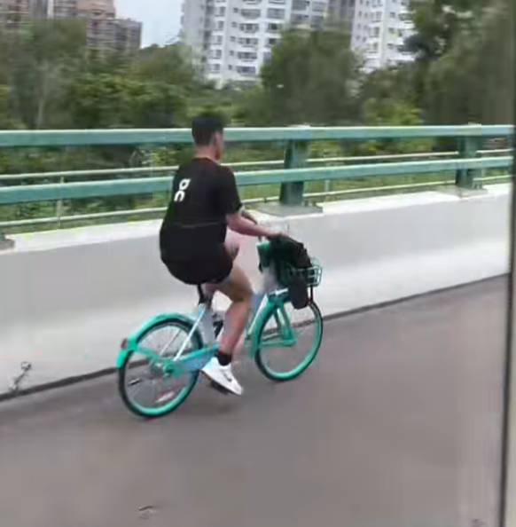 一名男子在屯門公路上沿着路肩踩共享單車。(影片截圖)