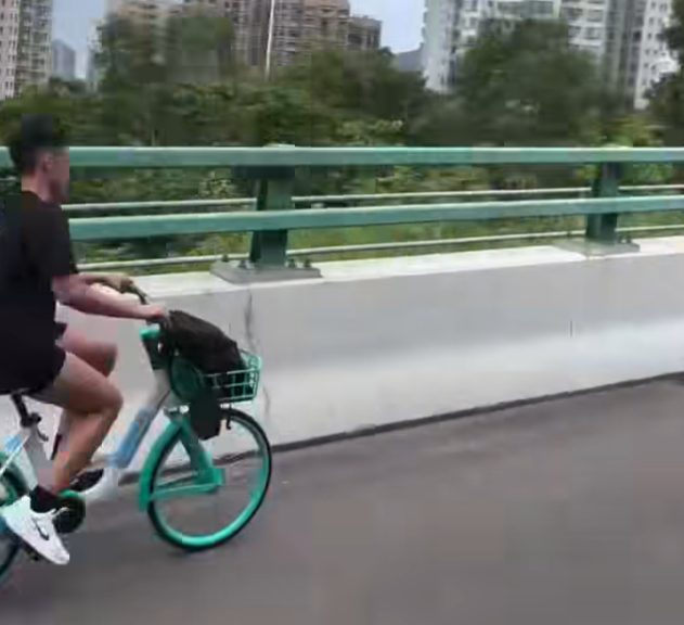一名男子在屯門公路上沿着路肩踩共享單車。(影片截圖)