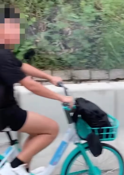 一名男子在屯門公路上沿着路肩踩共享單車。(影片截圖)