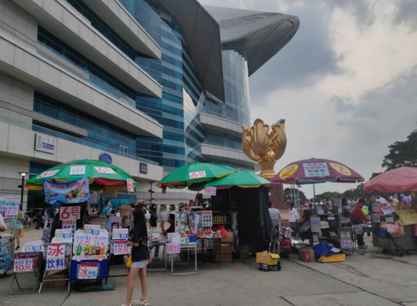 灣仔金紫荊廣場出現大量簡體字露天小販攤檔,售賣旅遊用品、八寶粥、飲品及紀念品,有遊客及網民形容感覺是「秒回國內」,仿如到了深圳東門夜市一樣,更有人形容雜亂場景「烏煙瘴氣」。(小紅書)