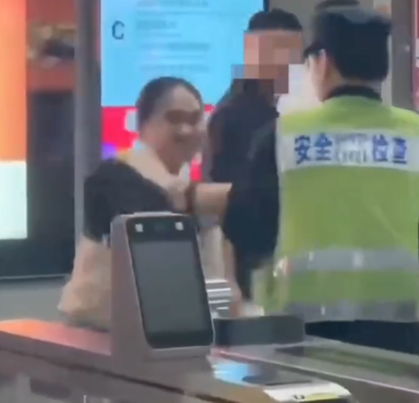 深圳地鐵女乘客以拳頭及手袋激烈追打一名的男安檢員,男方僅用手阻擋及後退,其後另外一名女安檢員上前制止,亦被女乘客用手袋重擊頭部。男安檢員隨即反手擒拿將女乘客制服,隨後女乘客躺臥在地不動。(影片截圖)