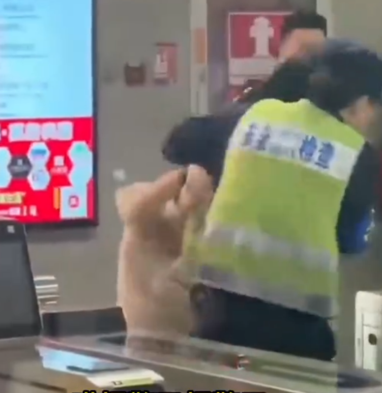 深圳地鐵女乘客以拳頭及手袋激烈追打一名的男安檢員,男方僅用手阻擋及後退,其後另外一名女安檢員上前制止,亦被女乘客用手袋重擊頭部。男安檢員隨即反手擒拿將女乘客制服,隨後女乘客躺臥在地不動。(影片截圖)