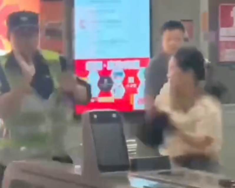 深圳地鐵女乘客以拳頭及手袋激烈追打一名的男安檢員,男方僅用手阻擋及後退,其後另外一名女安檢員上前制止,亦被女乘客用手袋重擊頭部。男安檢員隨即反手擒拿將女乘客制服,隨後女乘客躺臥在地不動。(影片截圖)