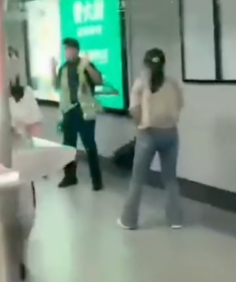 深圳地鐵女乘客以拳頭及手袋激烈追打一名的男安檢員,男方僅用手阻擋及後退,其後另外一名女安檢員上前制止,亦被女乘客用手袋重擊頭部。男安檢員隨即反手擒拿將女乘客制服,隨後女乘客躺臥在地不動。(影片截圖)