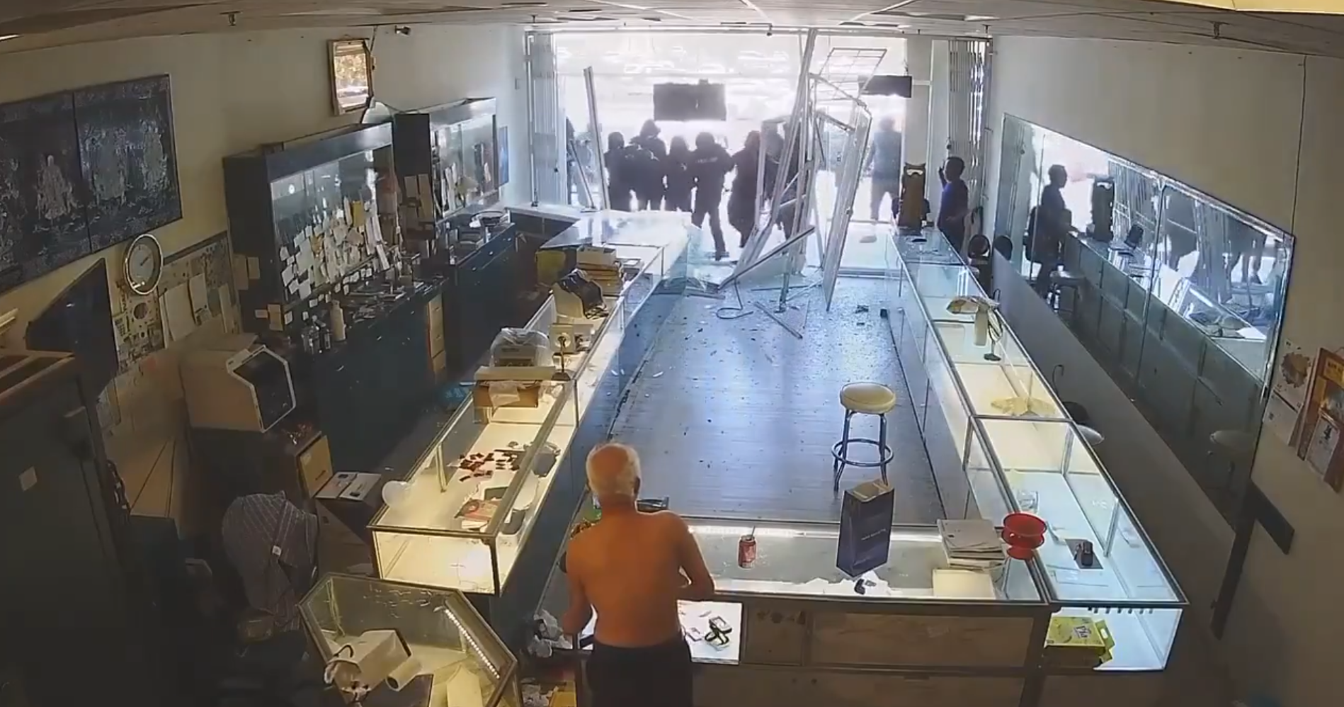 大批劫匪用斧頭、鐵鎚猛砸玻璃櫃,搶走大量金飾與珠寶,畫面中老闆曾試圖阻止行搶,但被其中1名疑犯粗暴推倒,跌落在碎玻璃上受傷。