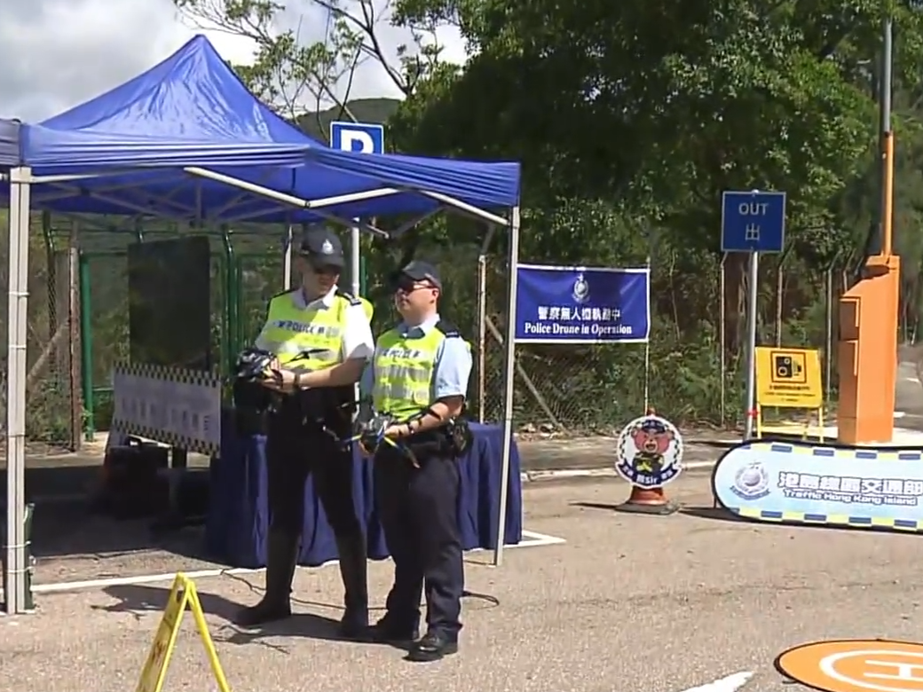 兩名警員以遙控器操作無人機。(now新聞截圖)