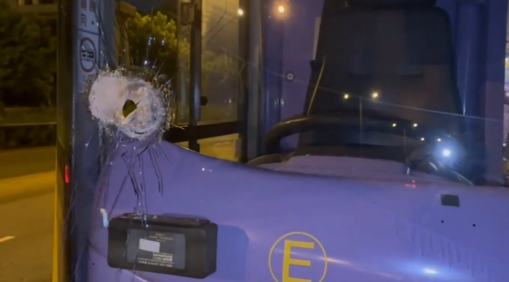 涉事城巴車頭擋風玻璃留下一個洞。(電視截圖)