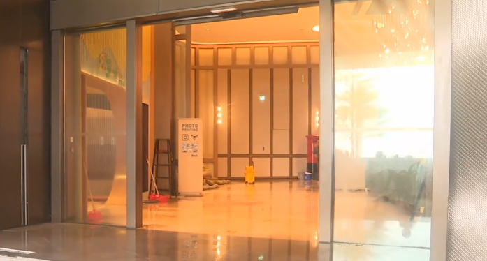 颱風樺加沙|富麗敦海洋公園酒店事後玻璃碎片散落一地,大堂內的大型盆栽擺設都被衝毀。有工作人員清理地上的泥水和積水,酒店外車路一片泥濘(有線新聞畫面)